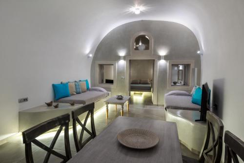 a living room with a table and chairs at Nefeli Homes - Adults Only in Imerovigli