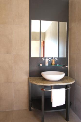 a bathroom with a sink and a mirror at The Finches Nest in  Hammanskraal 