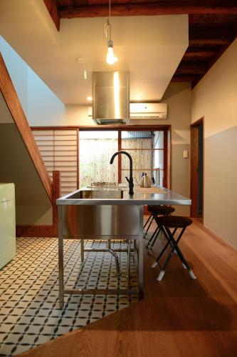 a kitchen with a sink in the middle of a room at Nanni Saiin Machiya in Kyoto