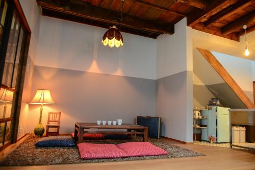 a living room with a table and red pillows at Nanni Saiin Machiya in Kyoto