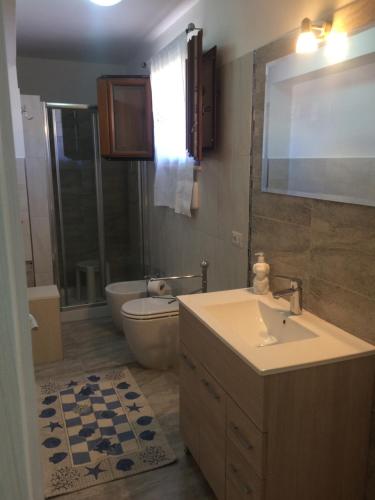 a bathroom with a sink and a toilet and a tub at Villa Scalea in Santa Domenica