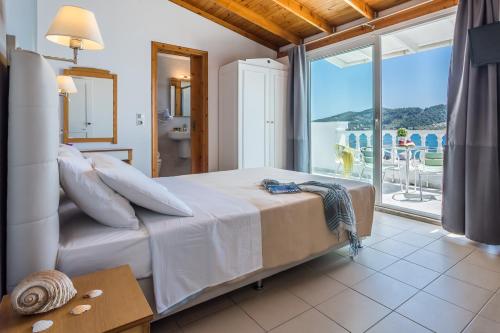 a bedroom with a bed with a view of the ocean at Hotel Akti in Skiathos