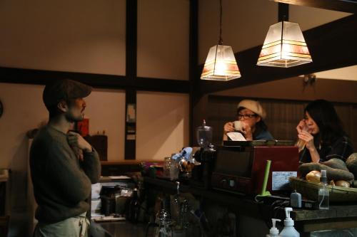 a man and a woman sitting at a bar at Guest House Kamejikan -turtle time- in Kamakura