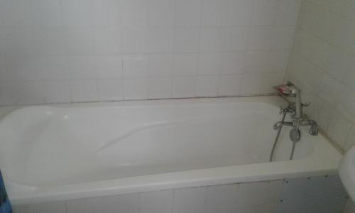 a white bath tub sitting next to a white sink at Skyway Hotel in Entebbe