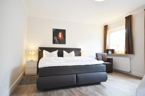 a bedroom with a bed and a chair in it at Ostseehaus Dreesen in Timmendorfer Strand