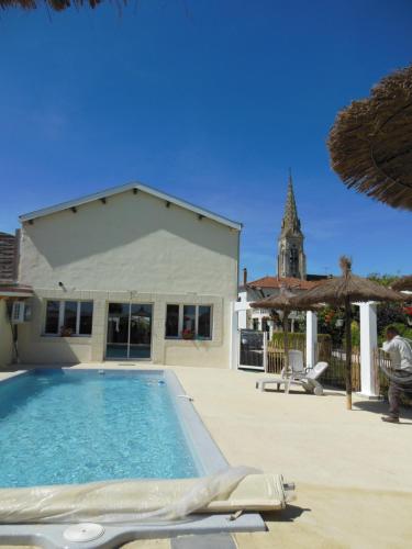 une piscine devant une maison dans l'établissement Le Fief de la Ribeyre, à Queyrac