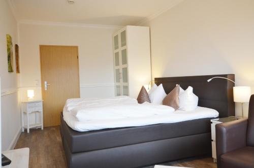a bedroom with a bed with white sheets and pillows at Ostseehaus Dreesen in Timmendorfer Strand