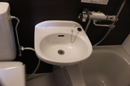 a bathroom with a white sink and a toilet at Nangoku Lodge Booya in Onna