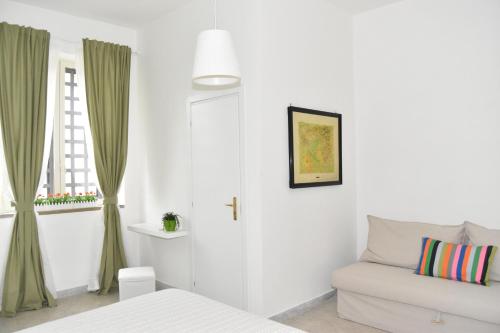 ein weißes Zimmer mit einem Sofa und einem Fenster in der Unterkunft sophie in Salerno