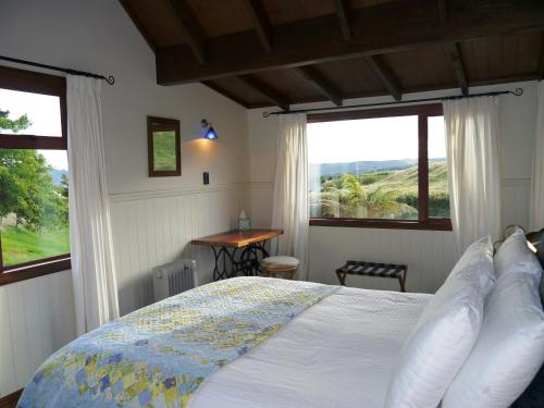 a bedroom with a bed and windows with a view at Country Lodge Kinloch in Taupo