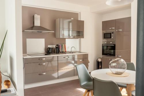 a kitchen with a table and chairs and a kitchen with stainless steel appliances at Lieblingsbude Schwerin in Schwerin