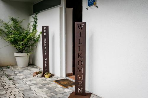 a sign outside of a door with a welcome sign at Ferienhaus Melita in Bleiburg