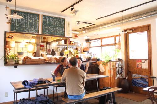 a group of people sitting at a counter in a restaurant at Guest House Kamejikan -turtle time- in Kamakura