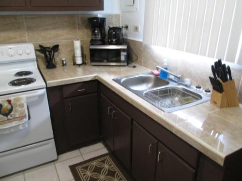 a kitchen with a sink and a stove at Pedro's Place in Tamuning