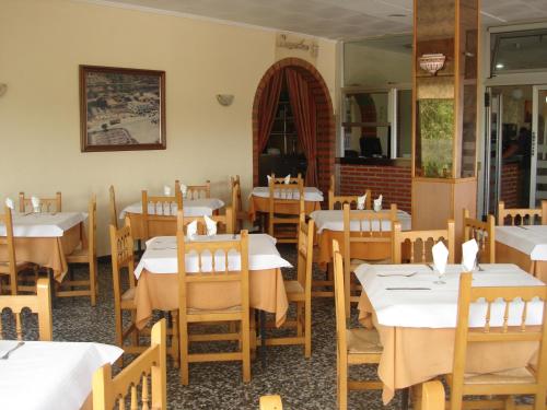 a restaurant with white tables and wooden chairs at Hostal Millán in Segorbe