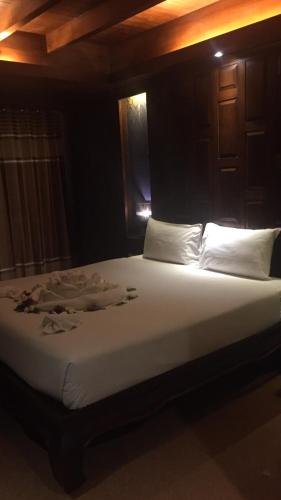a bed with white sheets and pillows in a room at JJ Residence in Phi Phi Don