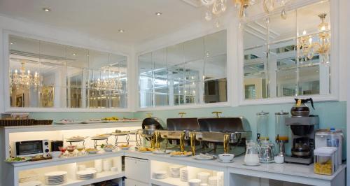 een keuken met witte kasten en een aanrecht met borden bij Luxury Old Quarter Hotel & Gym in Hanoi