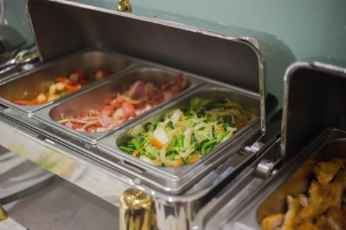 een buffet met twee schalen vol groenten en vlees bij Luxury Old Quarter Hotel & Gym in Hanoi