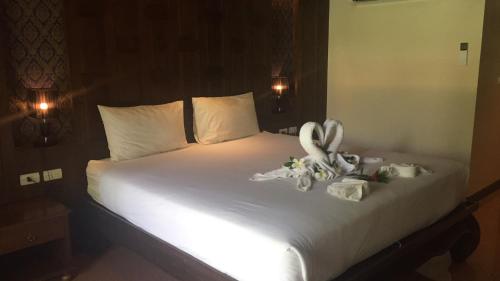 a bed with white sheets and stuffed animals on it at JJ Residence in Phi Phi Don