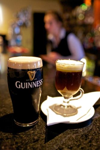 a glass of beer sitting on a table next to a drink at Broadhaven Bay Hotel in Belmullet