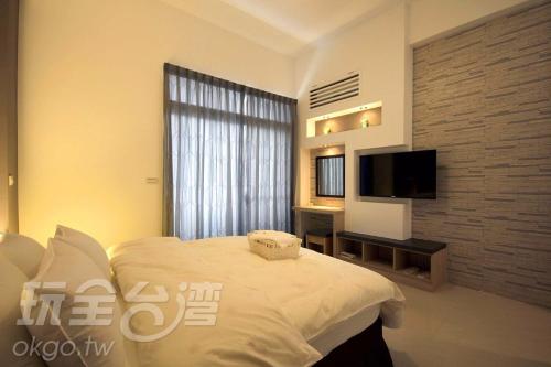 a bedroom with a bed and a flat screen tv at Wo in Puli