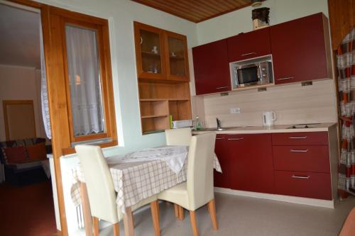 a kitchen with a table and chairs and a microwave at Frühstückspension Blasge in Bodensdorf