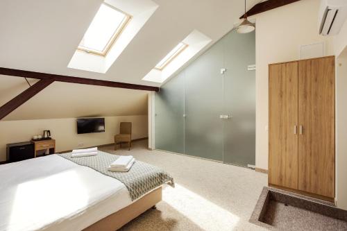 a bedroom with a bed and a tv and skylights at Old Town Trio in Vilnius