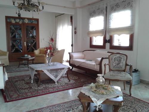 a living room with a couch and a table and chairs at Hotel Archontiko Dimitra in Vergina