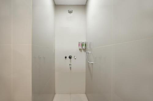 a shower with a glass door in a bathroom at Amaris Hotel Margorejo Surabaya in Surabaya