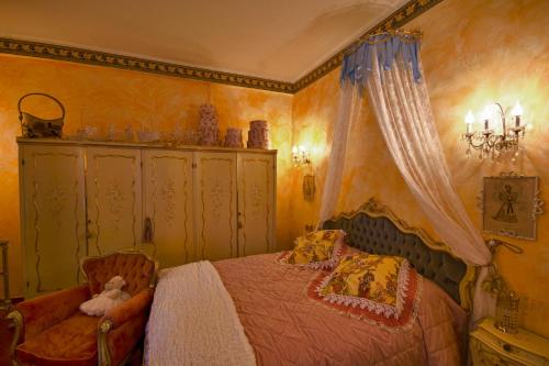 a bedroom with a bed and a chair at La maison delle favole in Desenzano del Garda