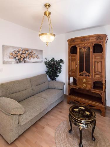 a living room with a couch and a wooden cabinet at Hotel Pazo de Berbetoros in Portomarin