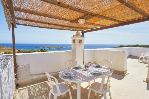 a table and chairs on a balcony with the ocean at Case Canino in Favignana