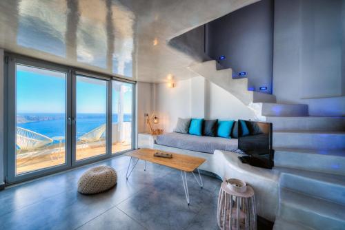 a living room with a couch and a view of the ocean at Nefeli Homes - Adults Only in Imerovigli