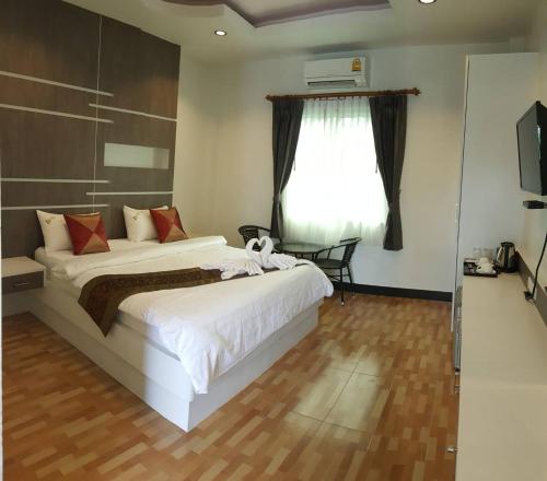 Un dormitorio con una gran cama blanca y una ventana. en Dusita Grand Resort, en Hat Yai