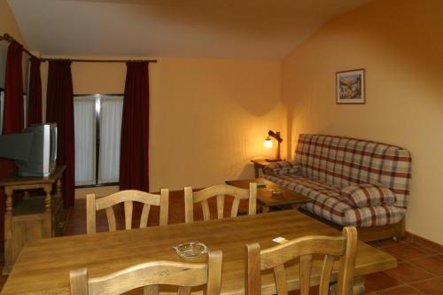 uma sala de estar com um sofá, uma mesa e cadeiras em Hotel y apartamentos La Casa Rural em Chinchón