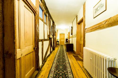 a hallway with a rug on the floor in a house at Molland Manor House Bed & Breakfast in Sandwich