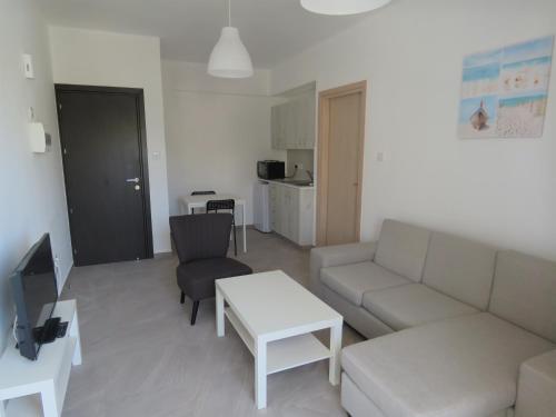 een woonkamer met een bank en een tafel bij Polyxeni Hotel Apartments in Limassol