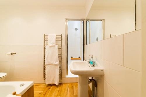 a white bathroom with a sink and a mirror at Molland Manor House Bed & Breakfast in Sandwich