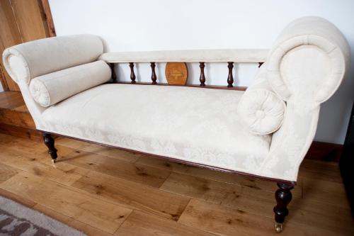 a white couch sitting on top of a wooden floor at Molland Manor House Bed & Breakfast in Sandwich