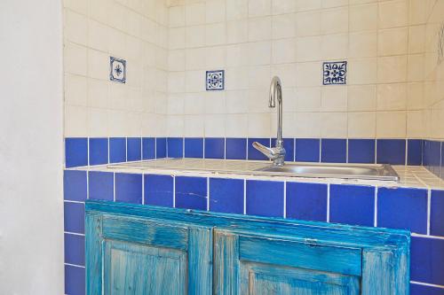 a kitchen with blue doors and a sink at Case Canino in Favignana