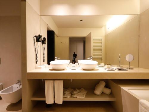 a bathroom with two sinks and a large mirror at Montebelo Vista Alegre Ílhavo Hotel in Ílhavo