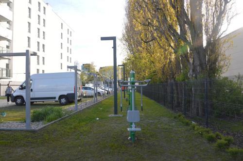 a white van parked in a parking lot next to a fence at Apartament z Ogrodem Gdansk Przymorze in Gdańsk