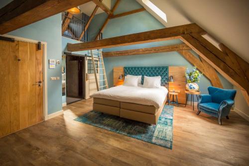 1 dormitorio con 1 cama y 1 silla azul en Van Rossum Stadshotel Woerden, en Woerden