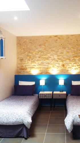 a room with two beds and two lamps on the wall at Le Clos de la Canéda in Sarlat-la-Canéda