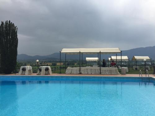 a large swimming pool with a table and a tent at Tenuta Due Laghi in Rivodutri