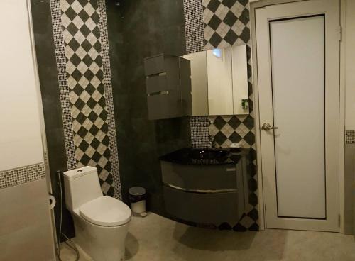 Un baño pequeño con inodoro y lavabo. en Dusita Grand Resort, en Hat Yai