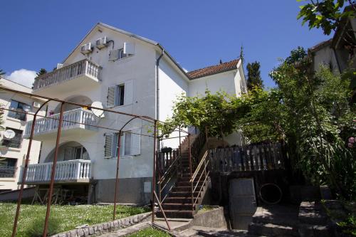 un edificio blanco con escaleras delante en St. Roko Guest House, en Tivat