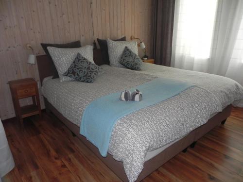 a bedroom with a bed with two stuffed animals on it at Appels en Peren Bed and Breakfast in Breezand