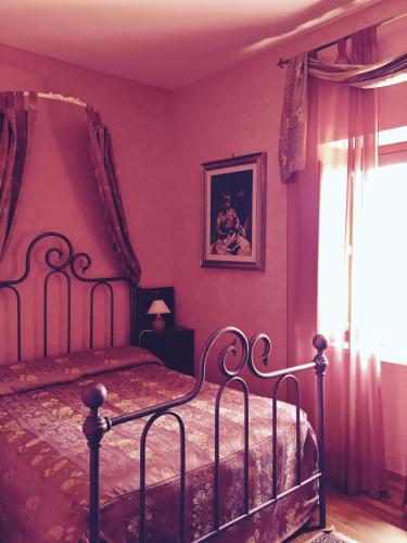 a bedroom with a bed with purple walls and a window at Tenuta Due Laghi in Rivodutri