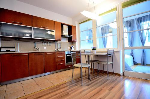 ソポトにあるVictus Apartamenty, Apartament Petitのキッチン(木製キャビネット、テーブル、椅子付)